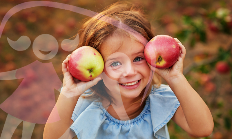 girl holding apples and smiling